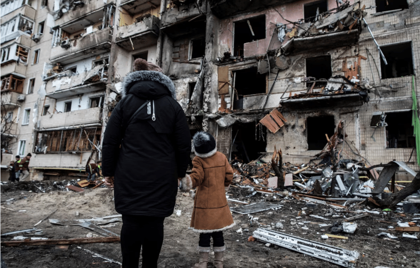 Finance4Learning | People look at a damaged residential building after a rocket attack in Kyiv on Feb. 25